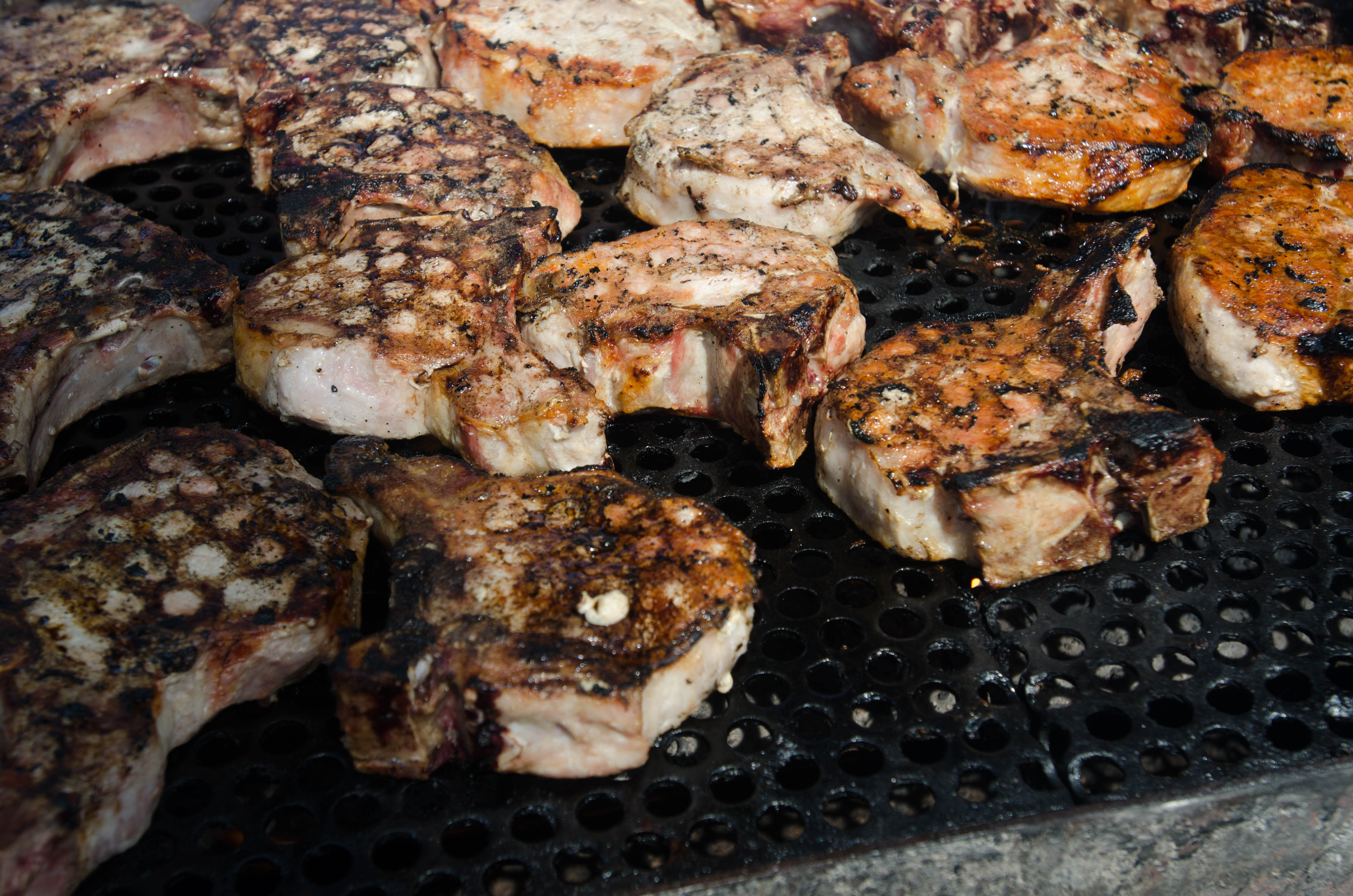 Pork cooks on a grill