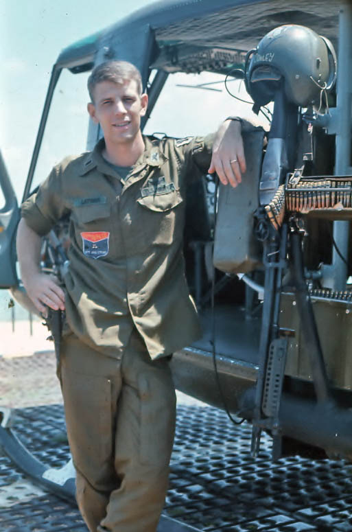 Soldier standing in from of huey in Vietnam