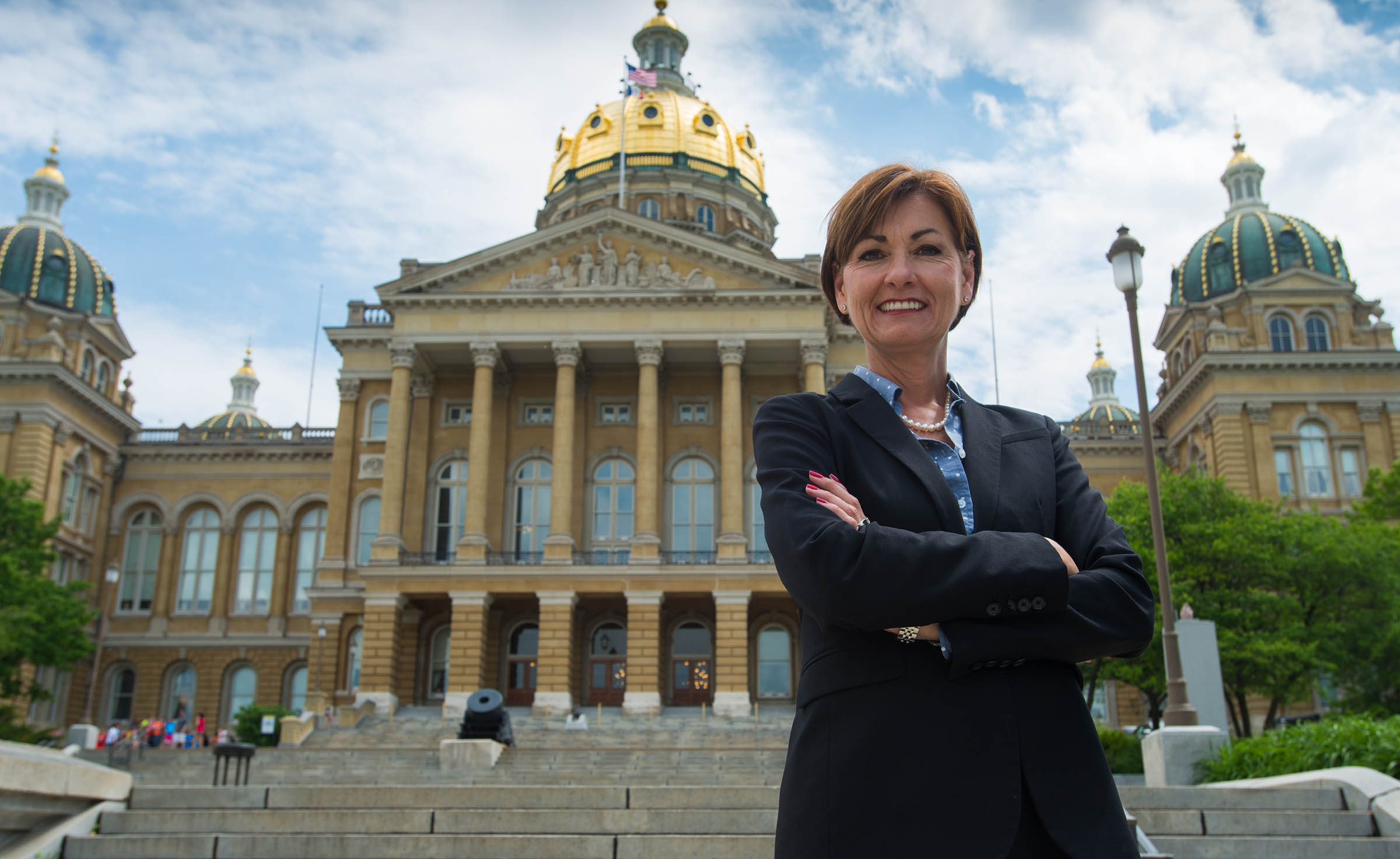 Governor Reynolds poses in front of the state capitol b