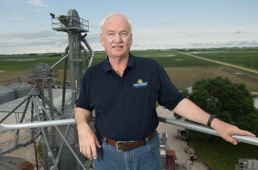 Ron Heck poses in a dark blue polo atop a grain elevato