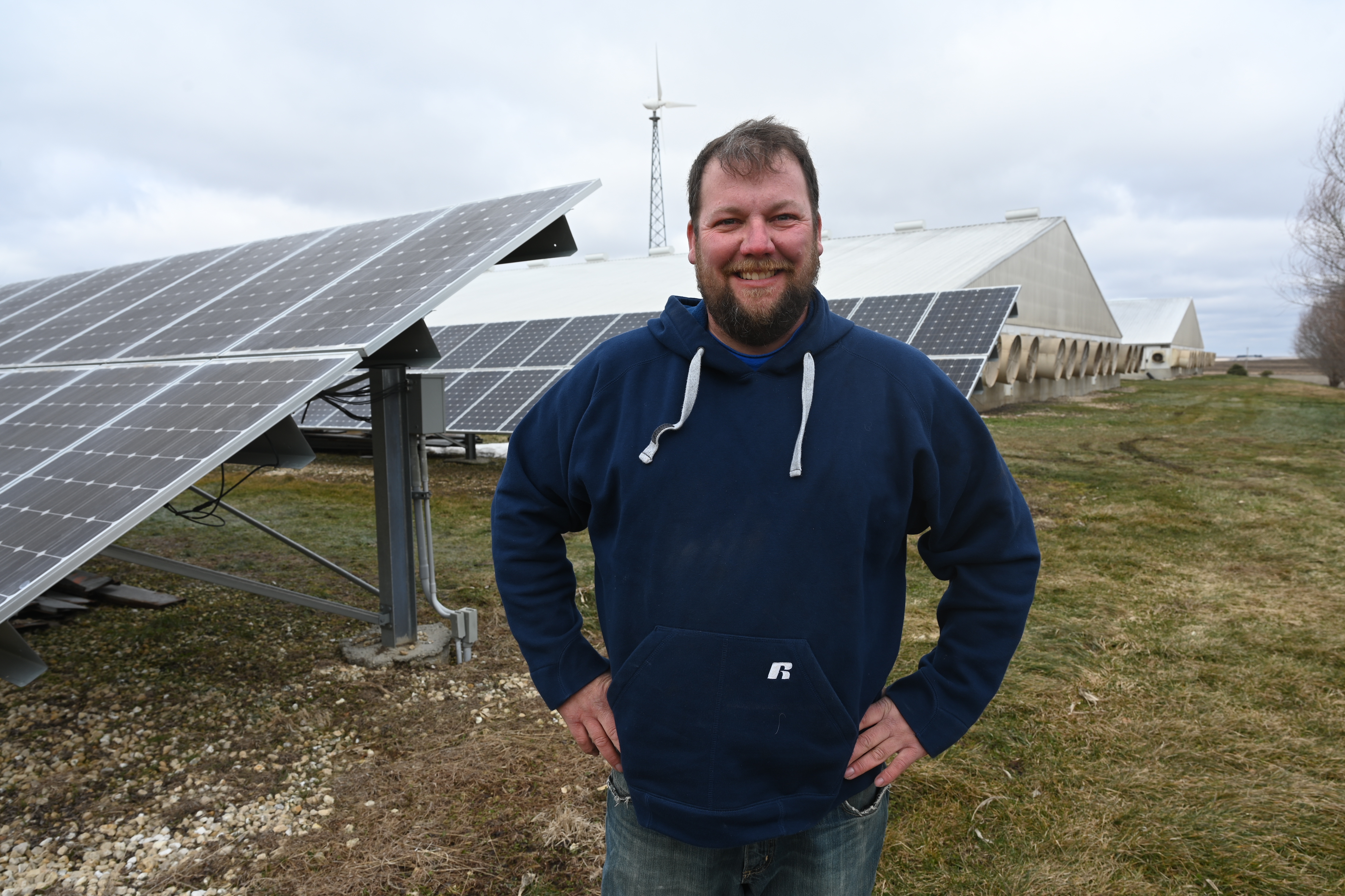 Jason Russell poses near his farm's solar panels
