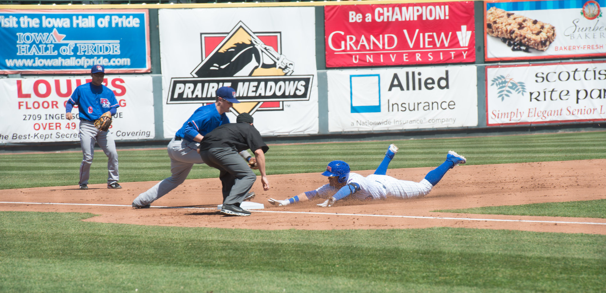 An Iowa Cubs player slides into third base