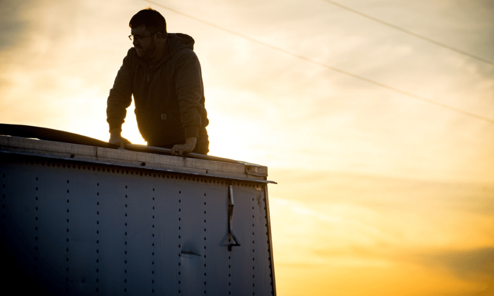 A farmer climbs onto his semi truck.