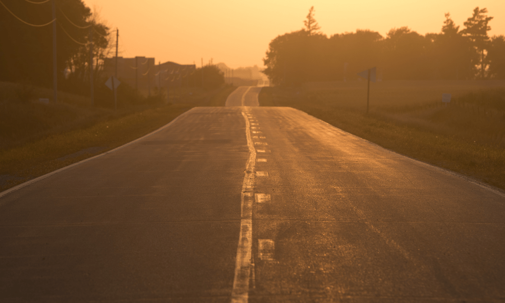 Sun glows golden on a paved road.