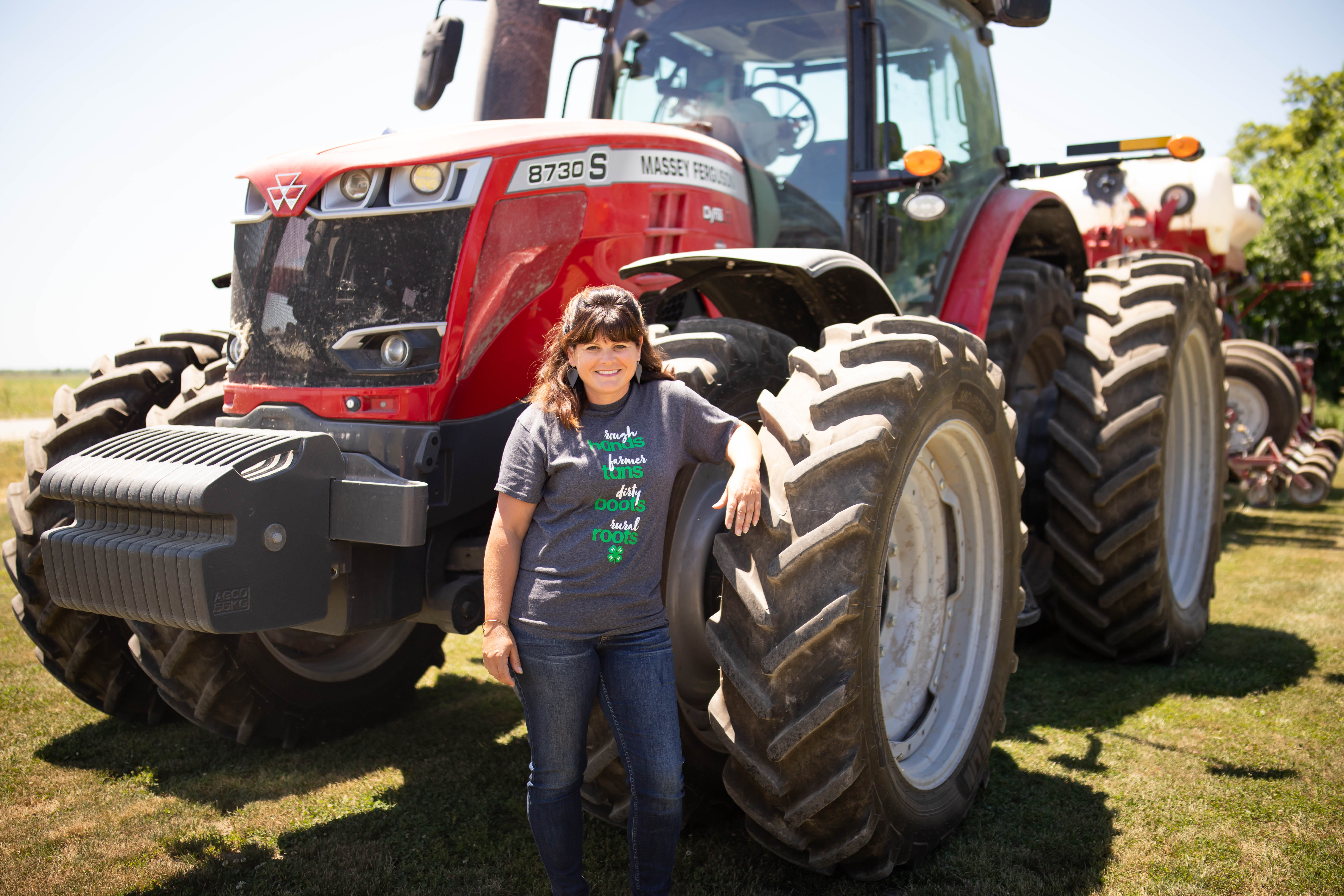 Paula Ellis poses in front of a tractor