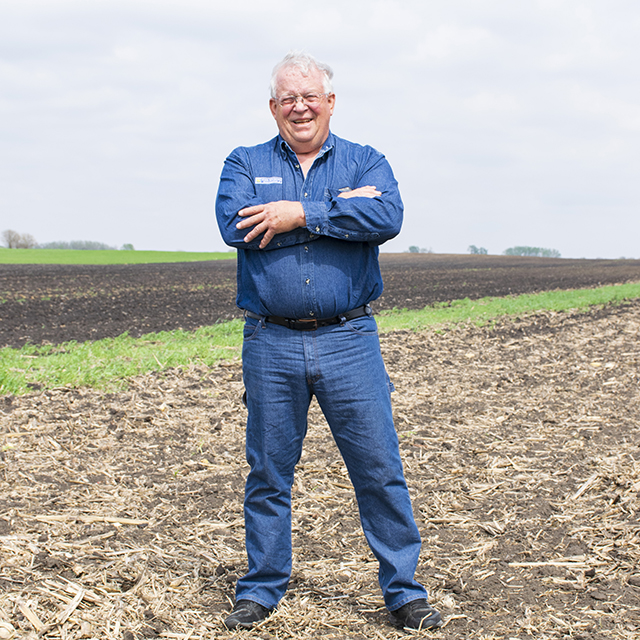 Pat Murken stands in the field in front of a buffer str