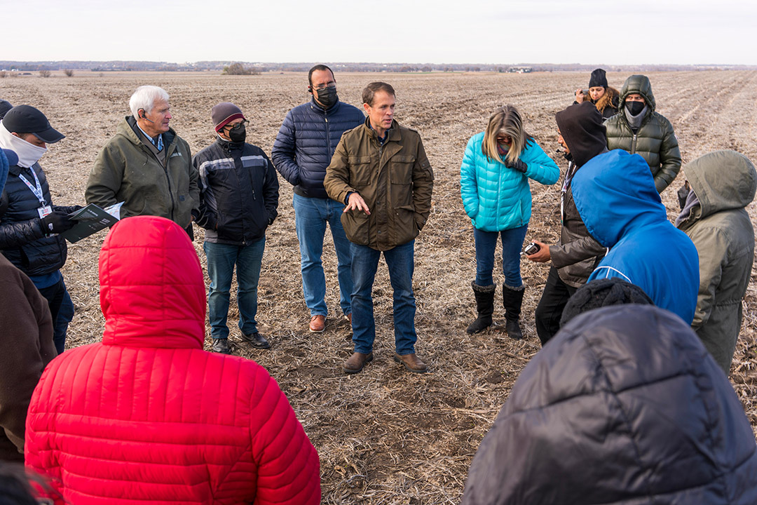 Grant Kimberley Presenting Iowa soybean farmer in field with group