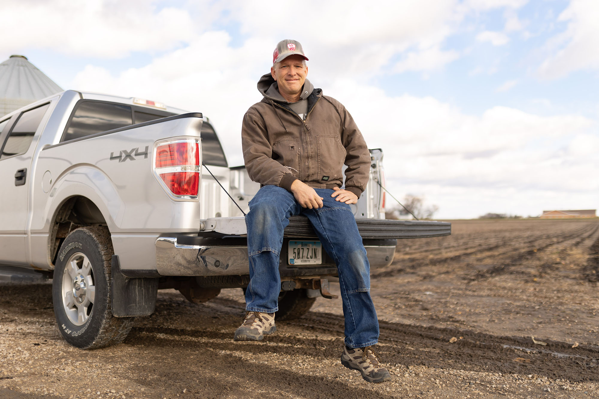 Soybean farmer sitting on truck tailgate 