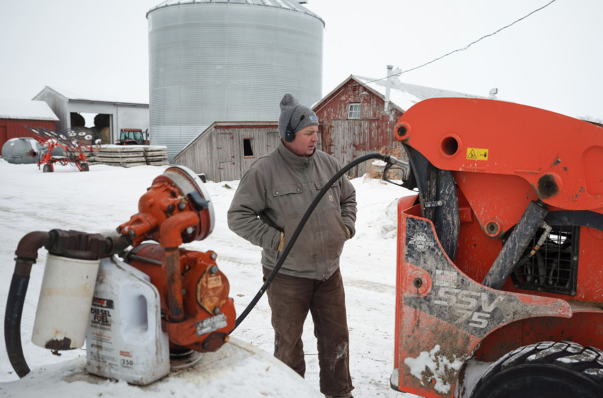 Farmer fueling up skid loader with biofuel