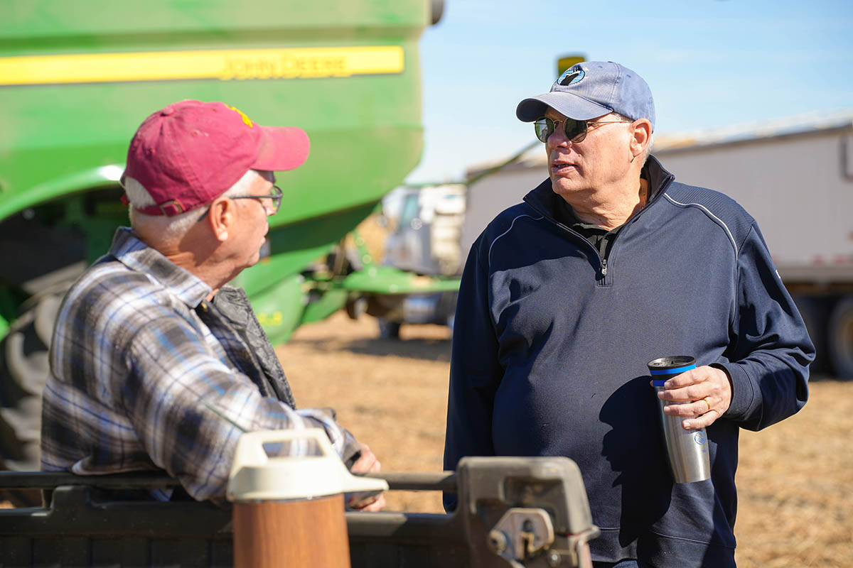 Farmer talking with Peter Mishek in soybean field