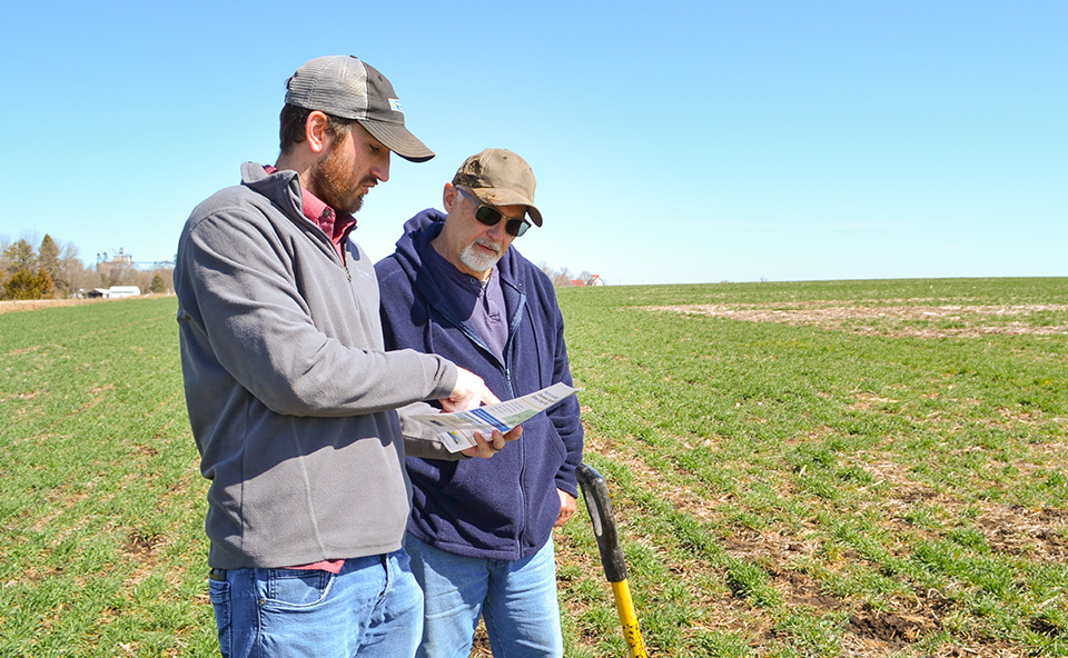 Farmer and conservation agronomist in field