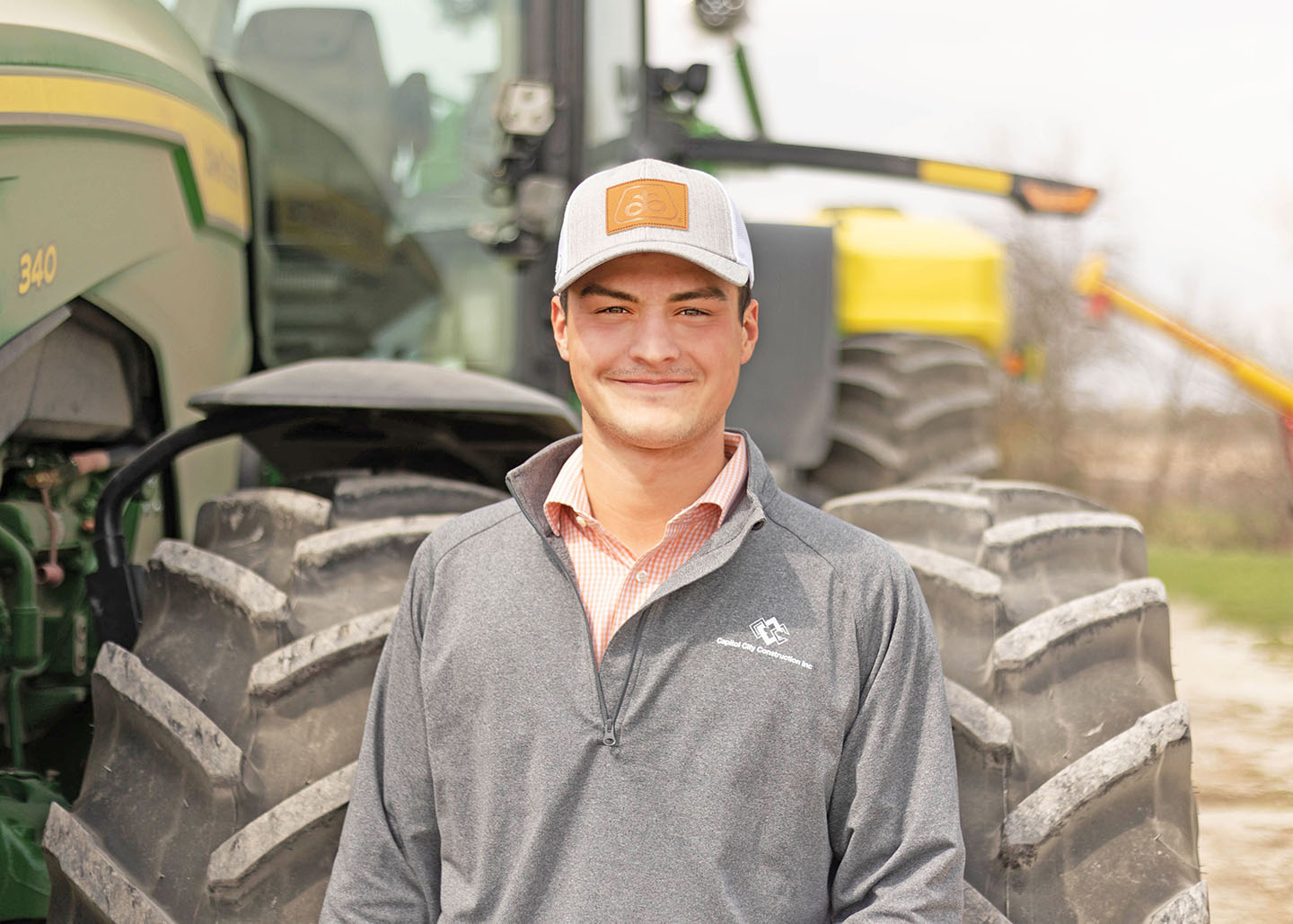 Young farmer from Lacona in front of tractor