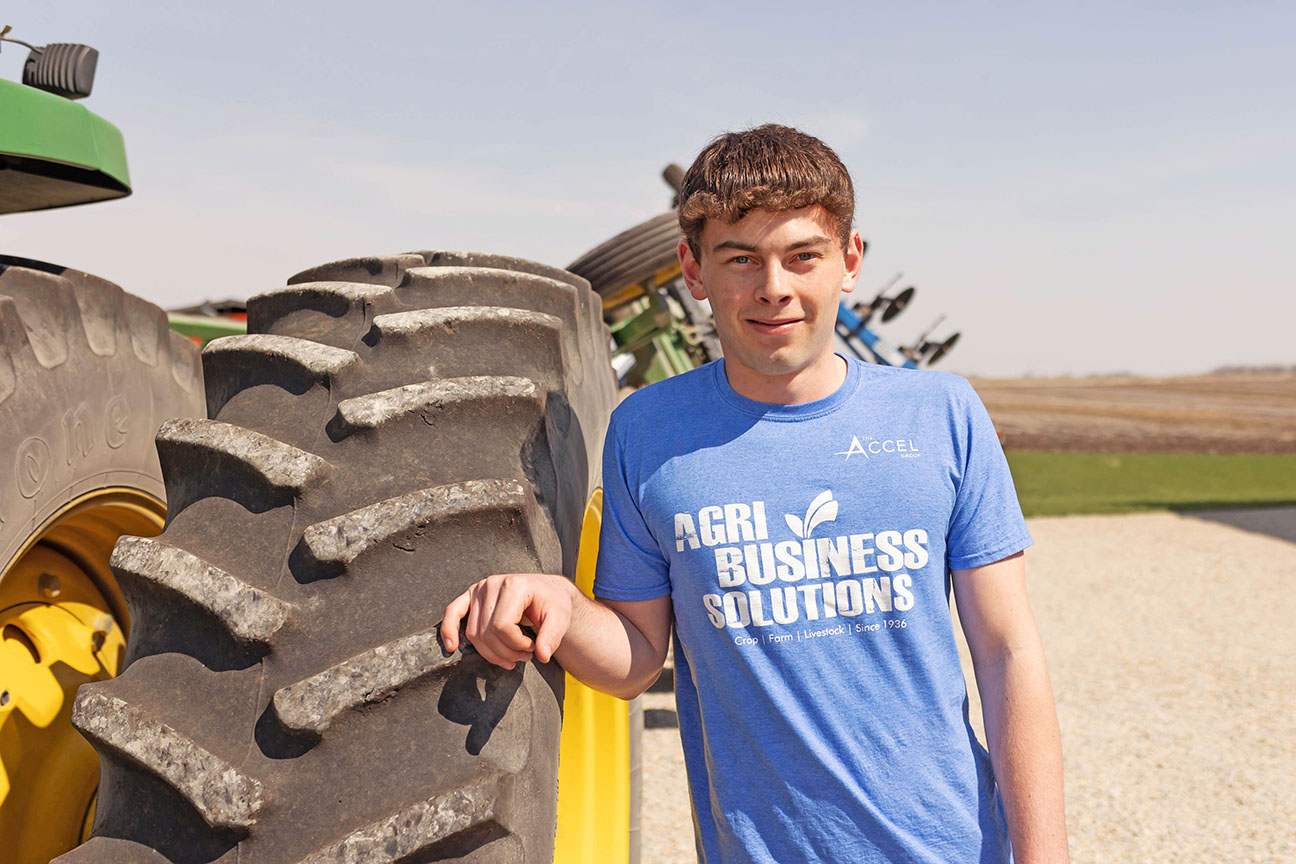 Young farmer standing next to tractor