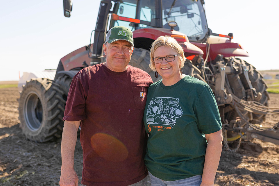 Soybean farmers standing next to red tractor