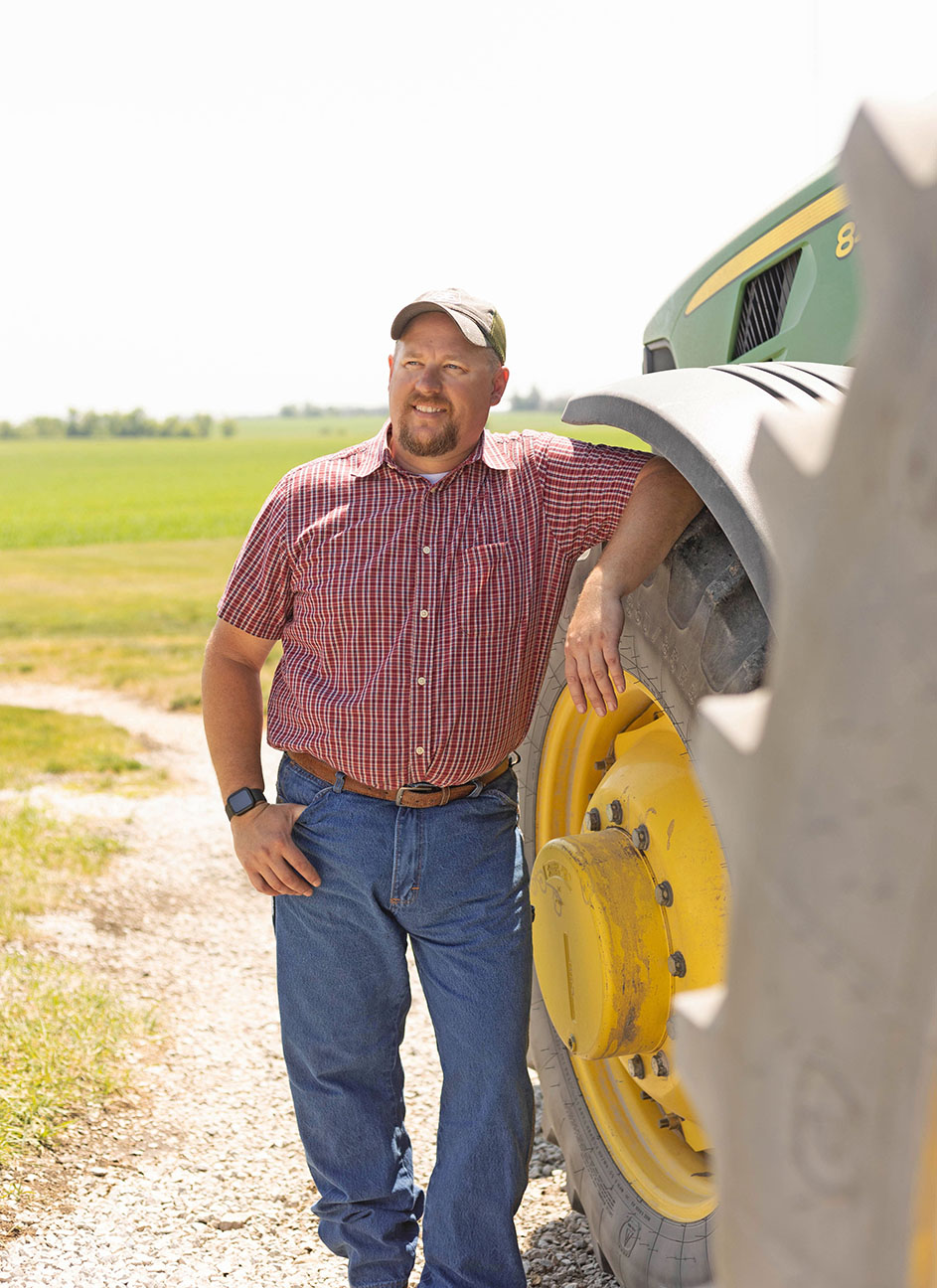 Farming standing next to John Deere tractor