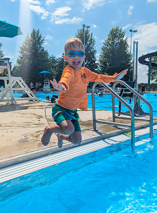 Child jumping into pool
