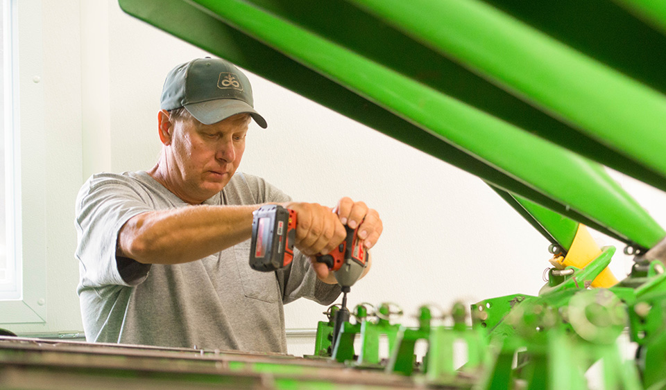 Farmer working on equipment for harvest