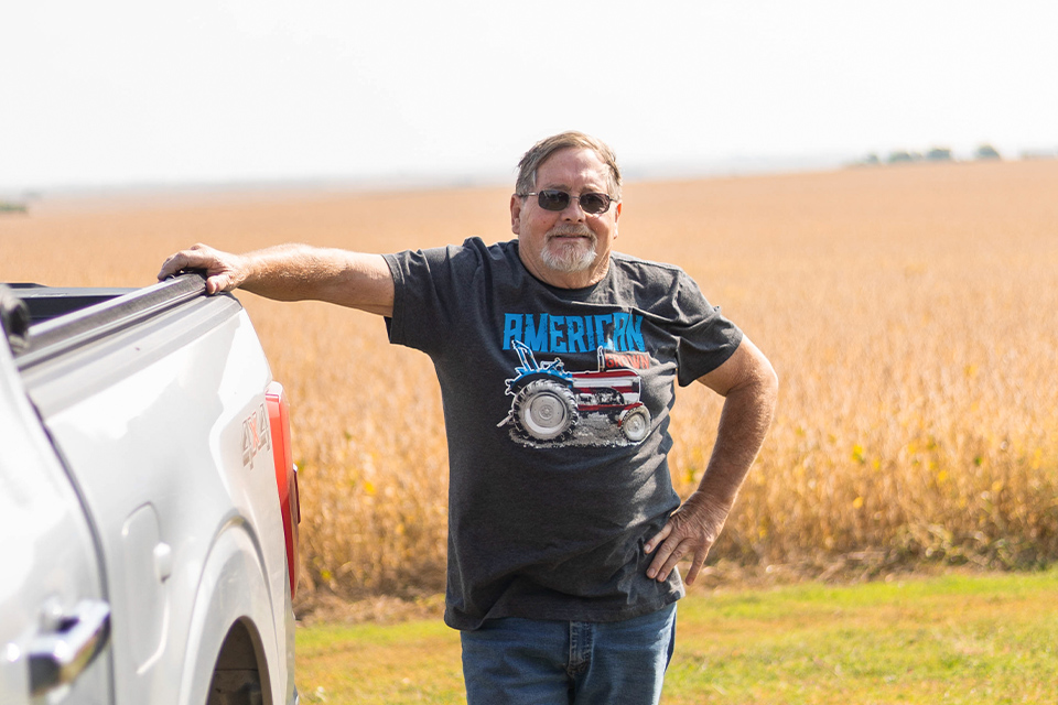 Farmer standing next to truck.