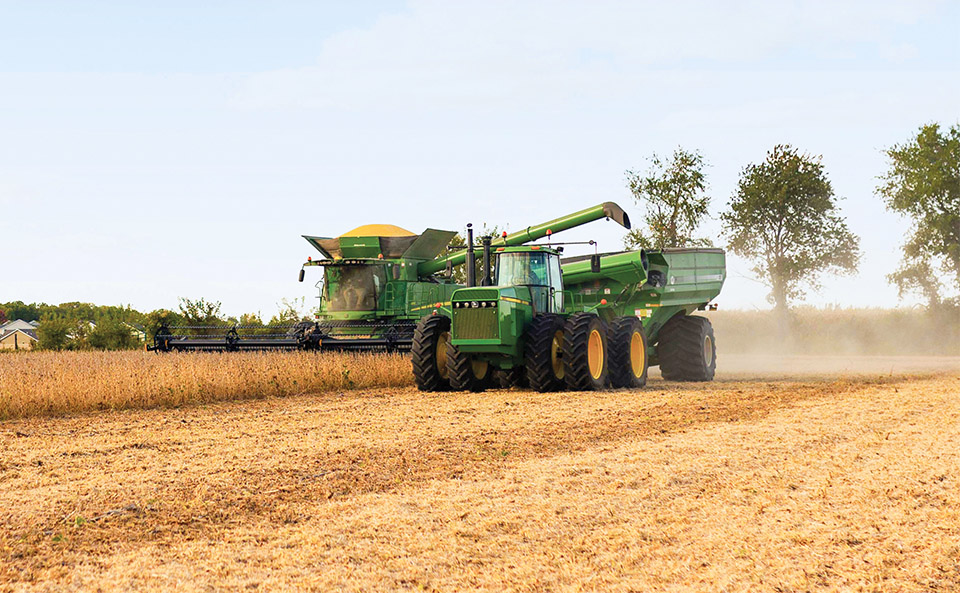 Harvesting soybeans John Deere Ag Equipment in Field