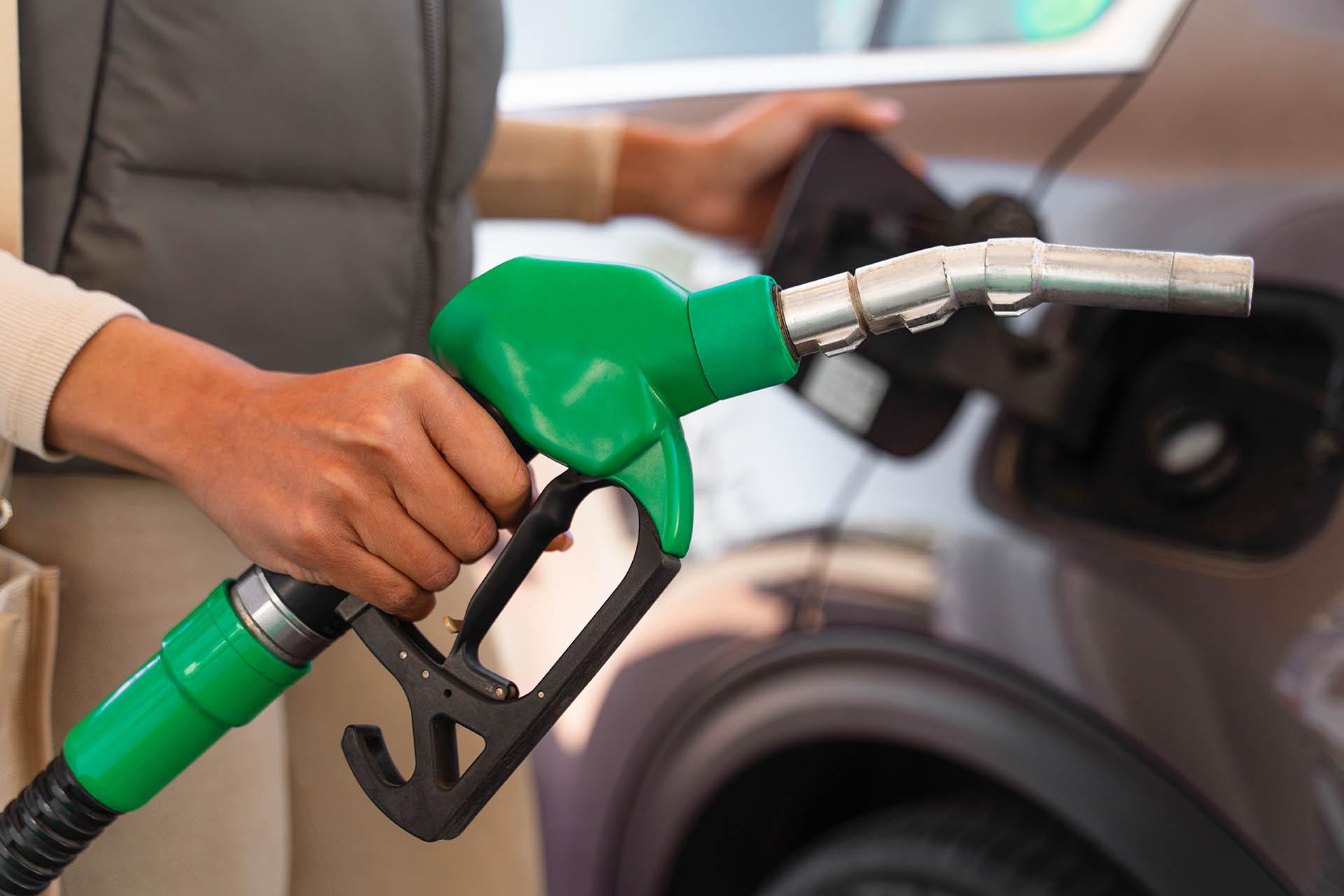 Woman filling up vehicle at gas station