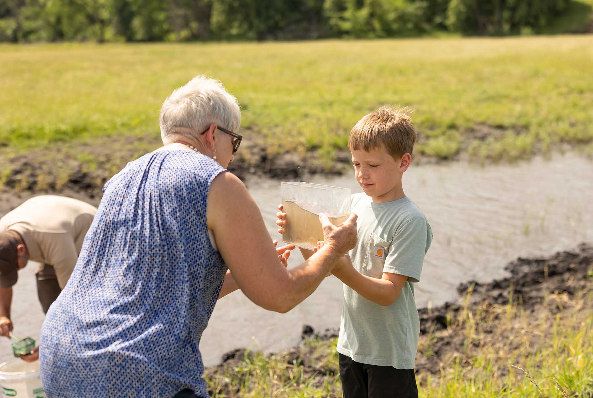 Young boy holding container of oxbow water