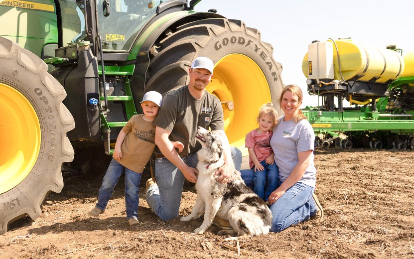 Josh Blair and Family Farm family next to tractor and planter