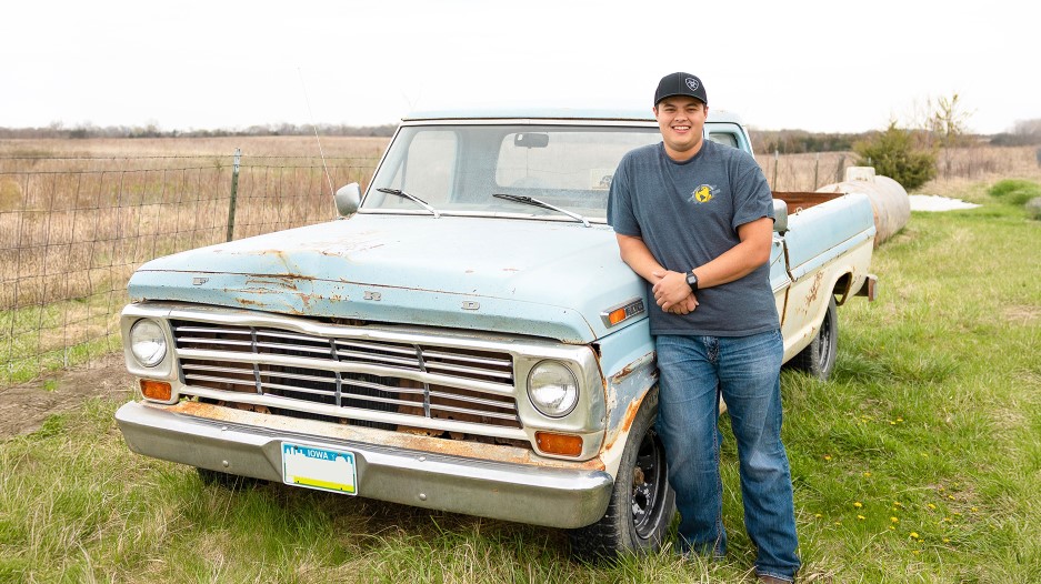 Jairus Davis Young ag professional standing next to old Ford truck