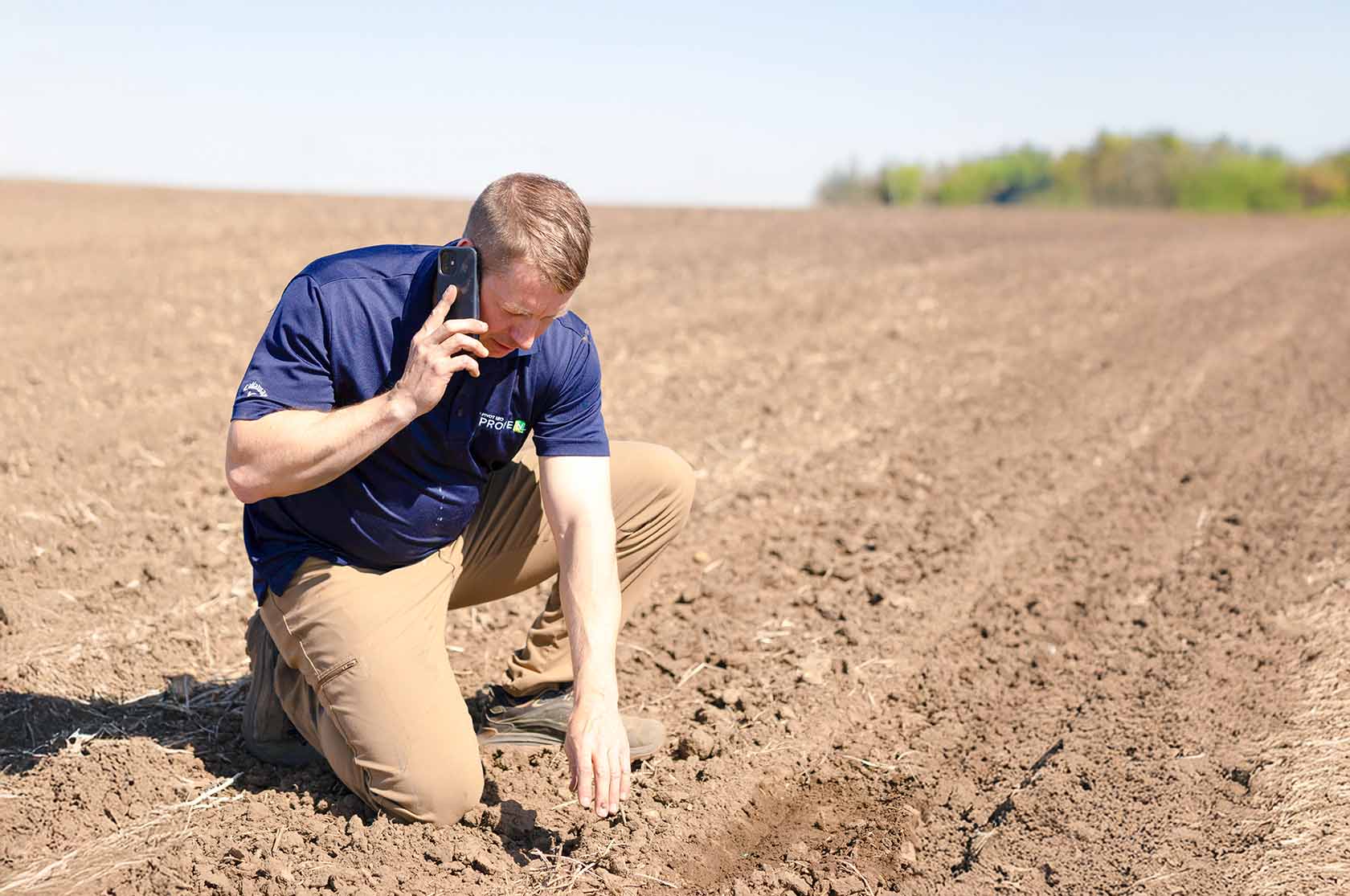 Tim Couser Farmer on phone while checking soybean seed