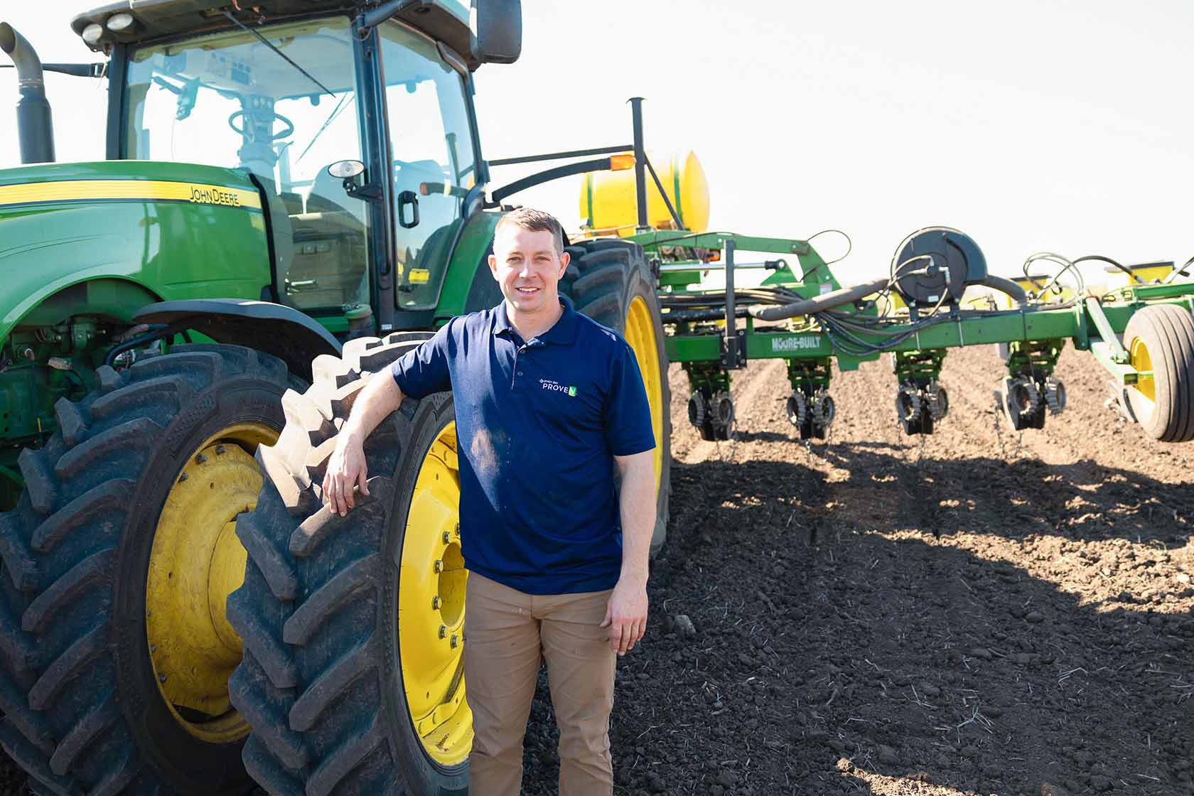 Iowa farmer standing next to John Deere tractor