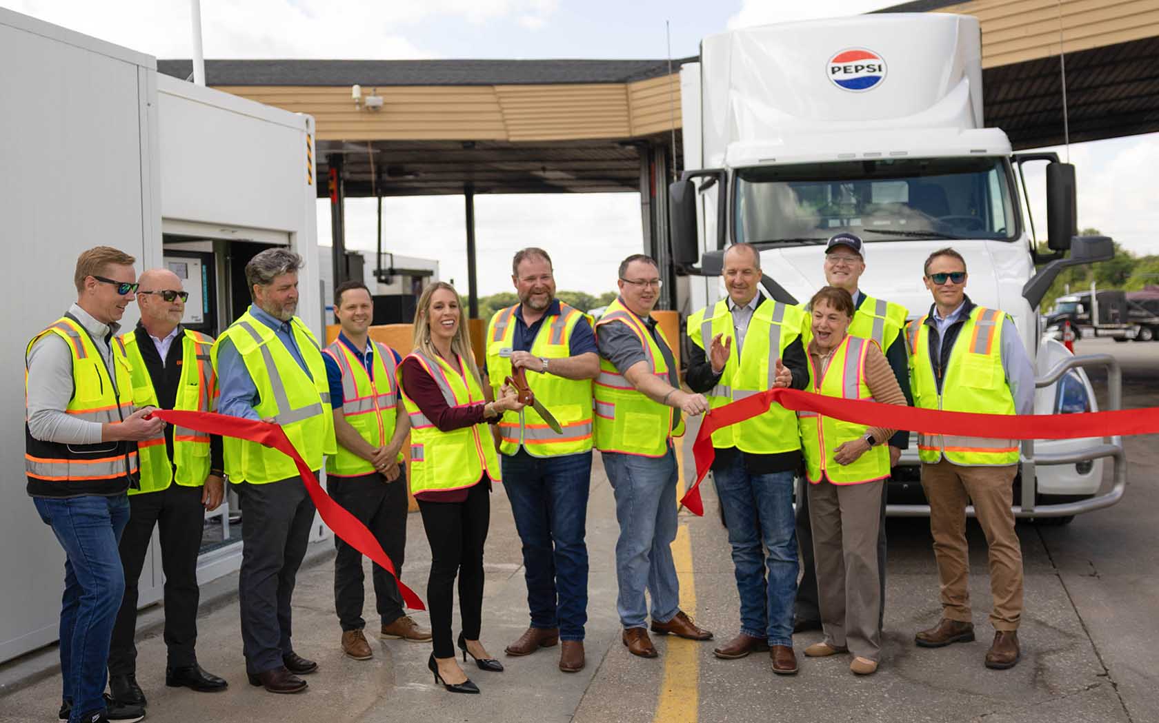 Biodiesel stakeholders cutting red ribbon at opening of