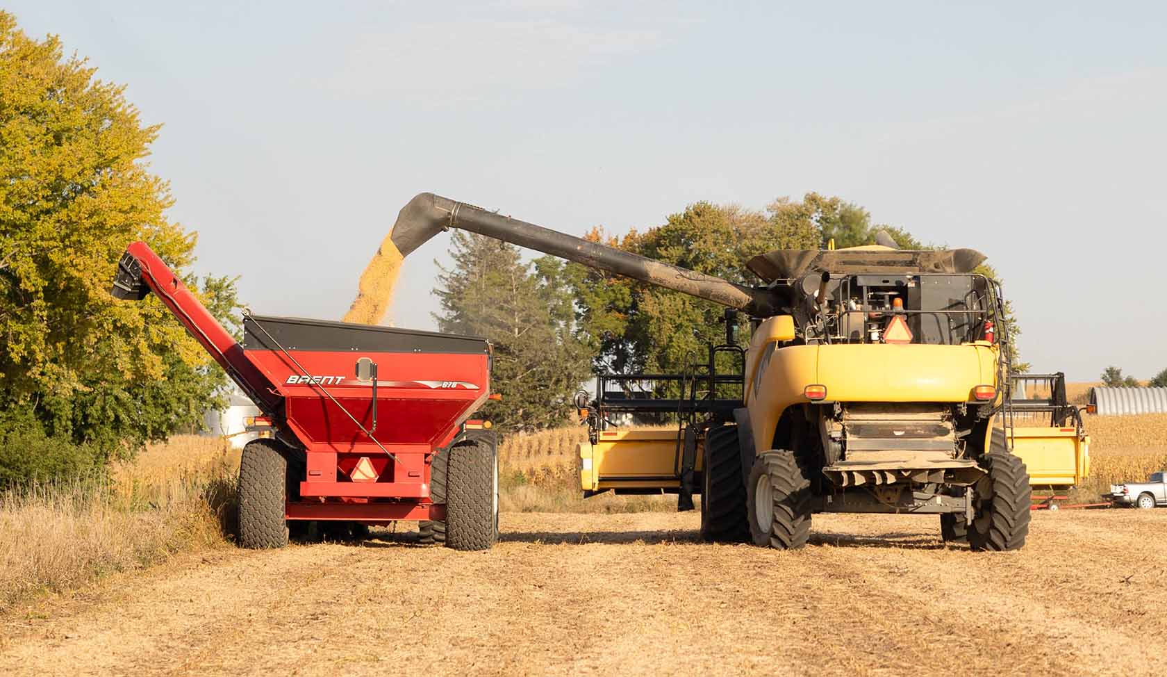 Combine filling up grain cart.