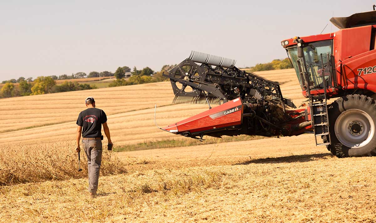 World Mental Health Day Farmer walking to combine with tools.