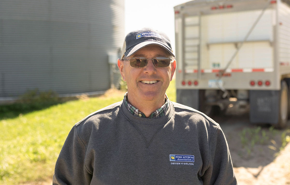 Randy Miller Iowa Soybean farmer standing by grain bins