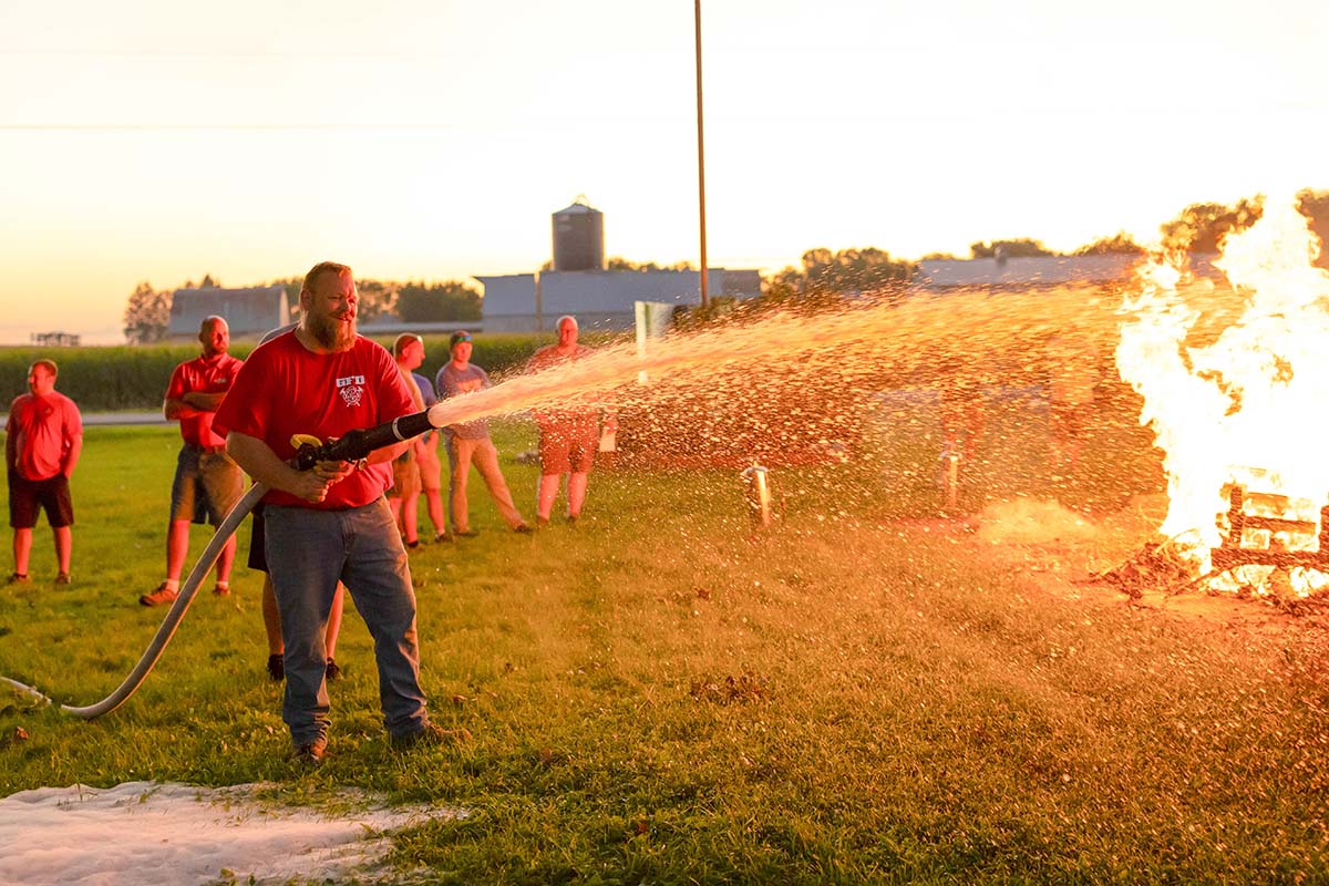 Firefighters spraying foam made from soybeans onto fire
