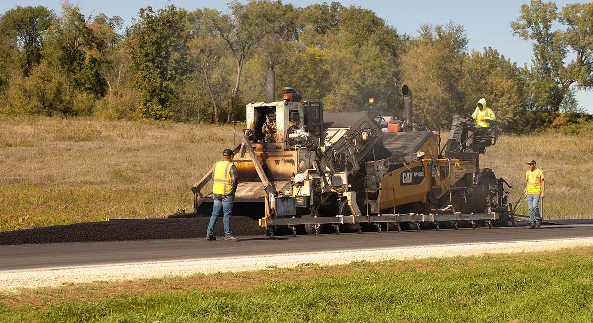Soy asphalt installed on rural roud Large asphalt machine with crew