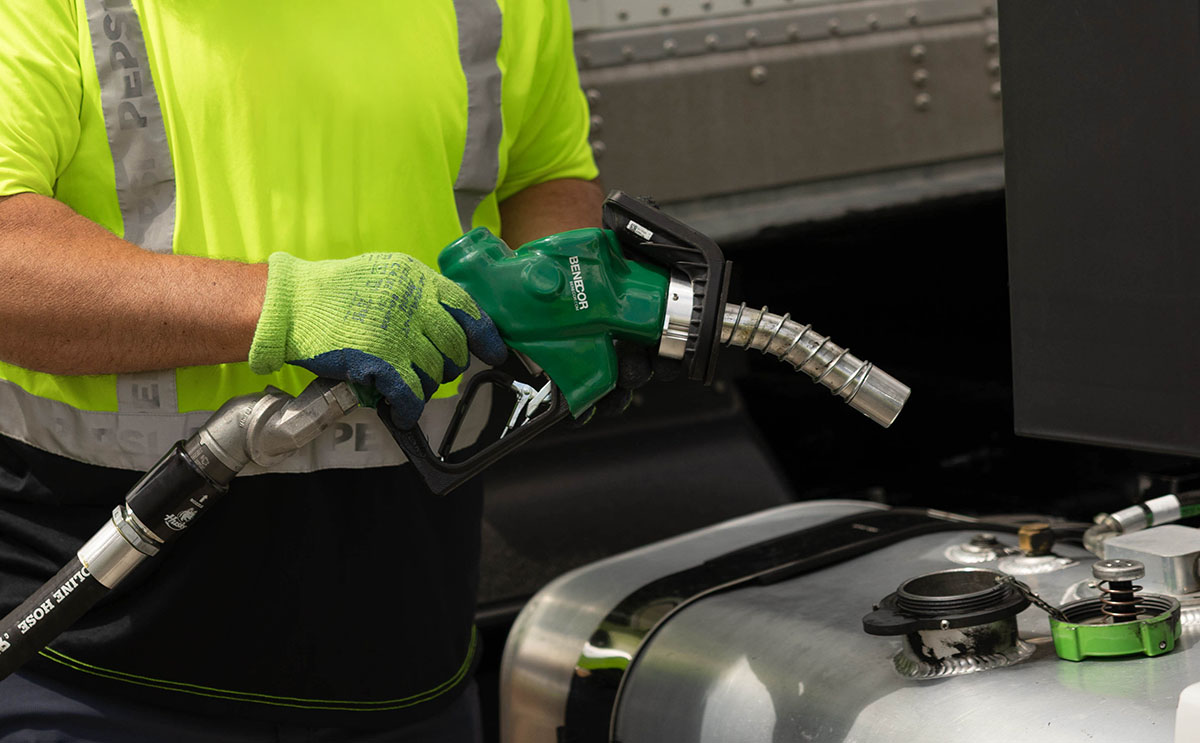 Man holding biofuel pump filling truck
