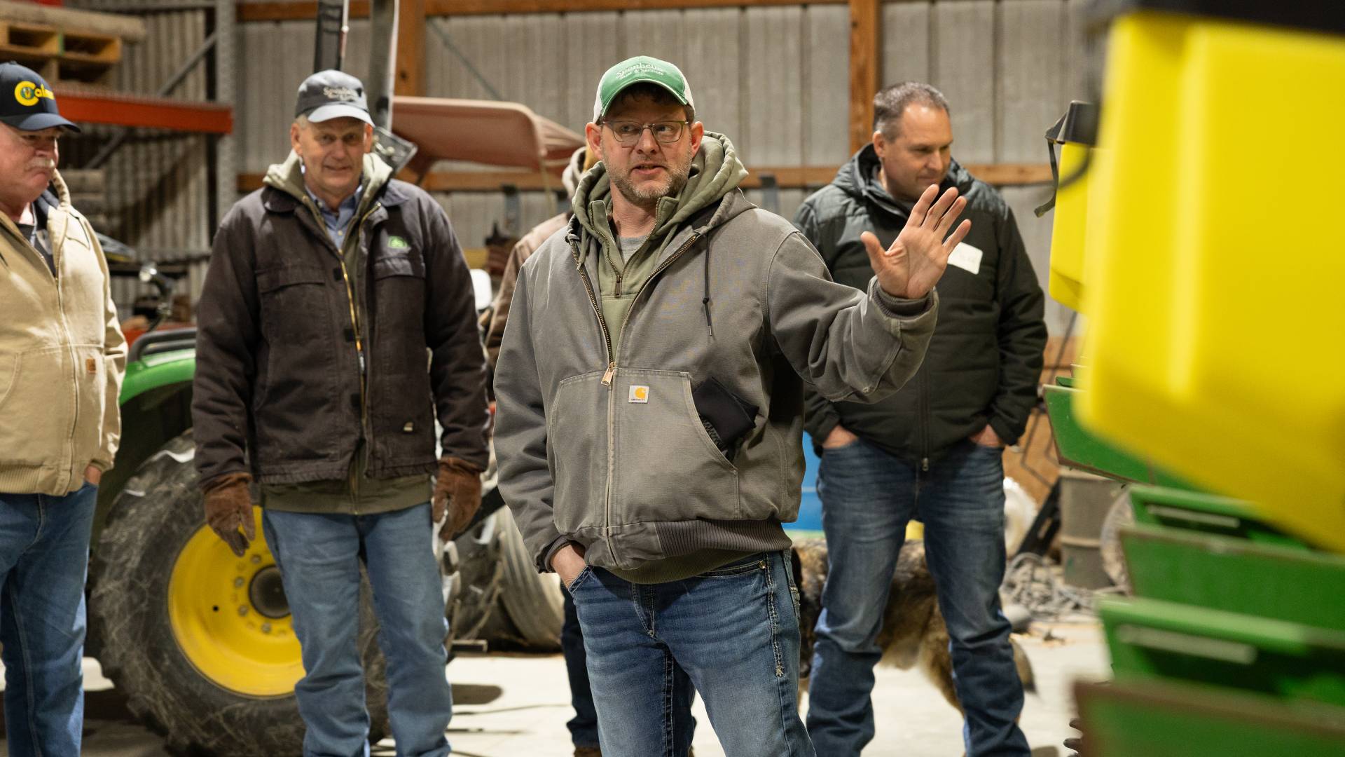 Farmers gathered around a planter talking about conserv