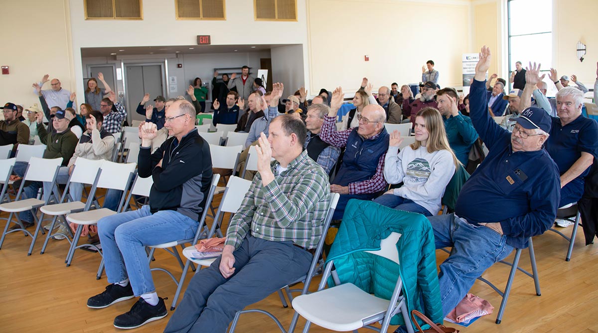 Farmers raising hands in response to question.