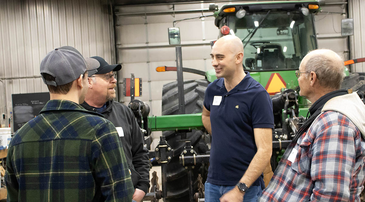 Farmer speaking with other farmers at shop talk