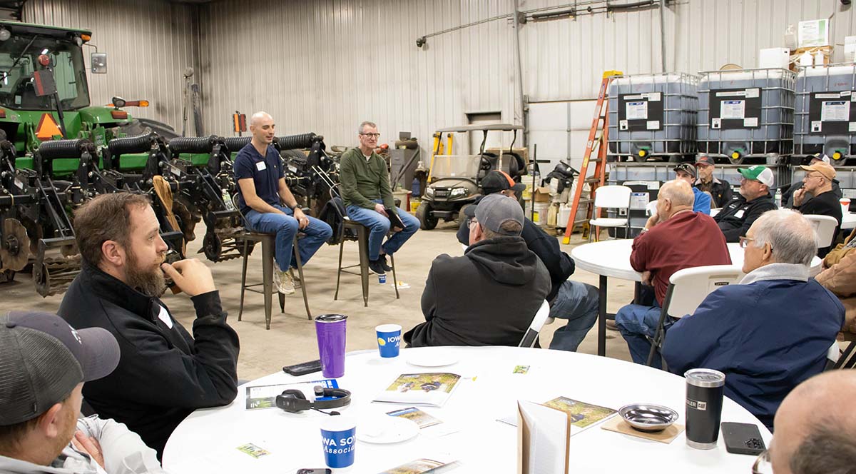 Two farmers speaking in front of others in farm shop