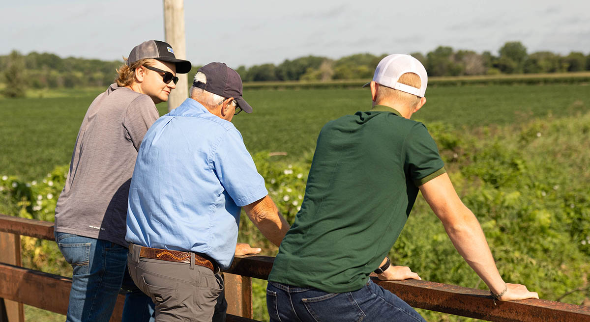Experience Class Conservation Stop Farmers looking over edge of bridge