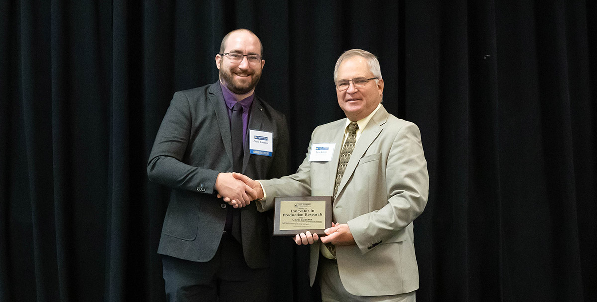 Innovator in Production Research Award Chris Gaesser accepting award from Tom Adam