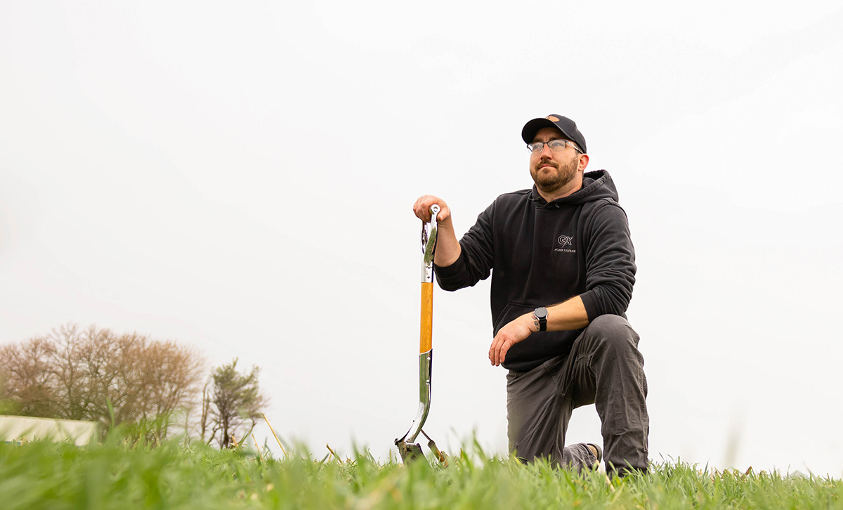 Farmer kneeing in cover crops