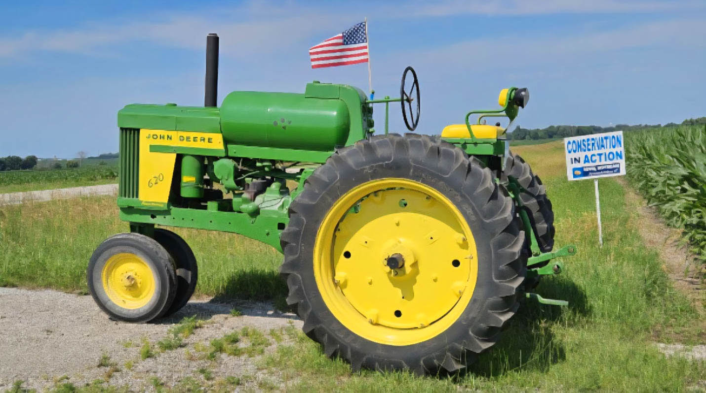 John Deere Tractor on Fourth of July Tractor next to Conservation in Action sign