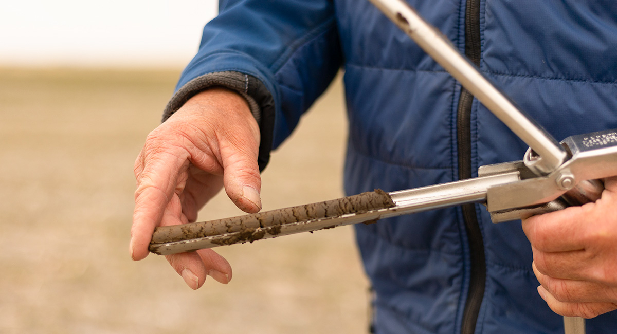 A Farmer Holds a Soil Probe Packed with Dirt