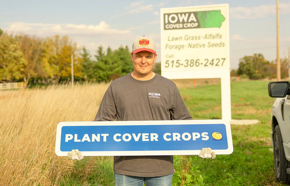Man Holds "Plant Cover Crops" Sign