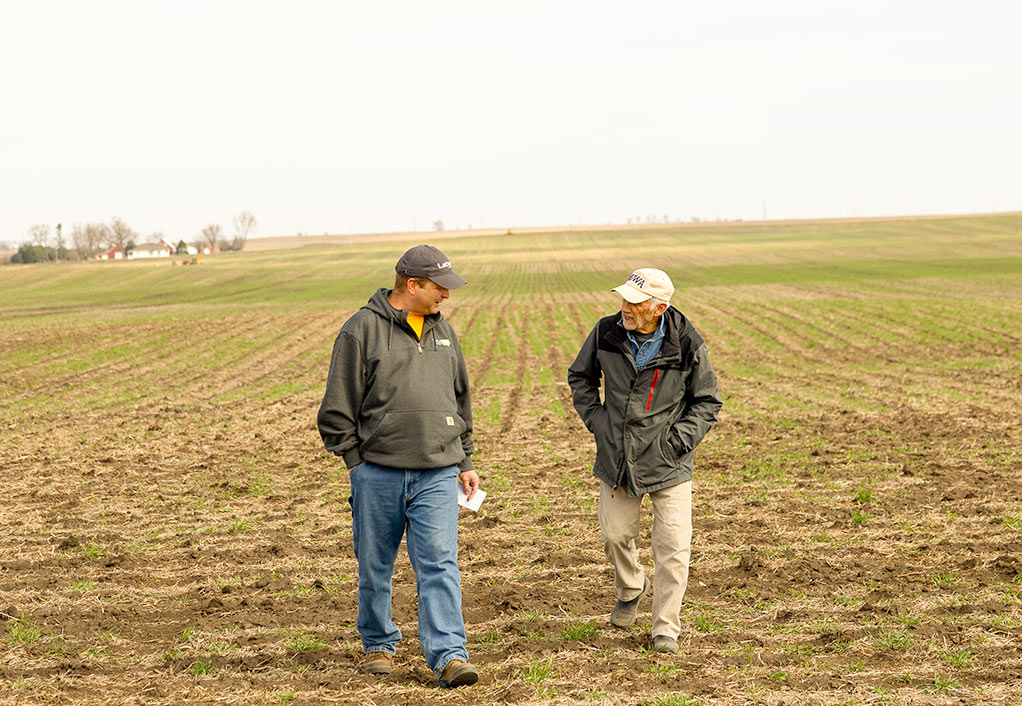 Two Men Walk in a Strip-Till Field