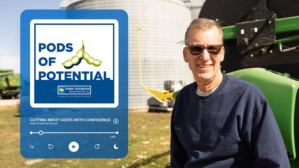 Farmer leans against John Deere combine head