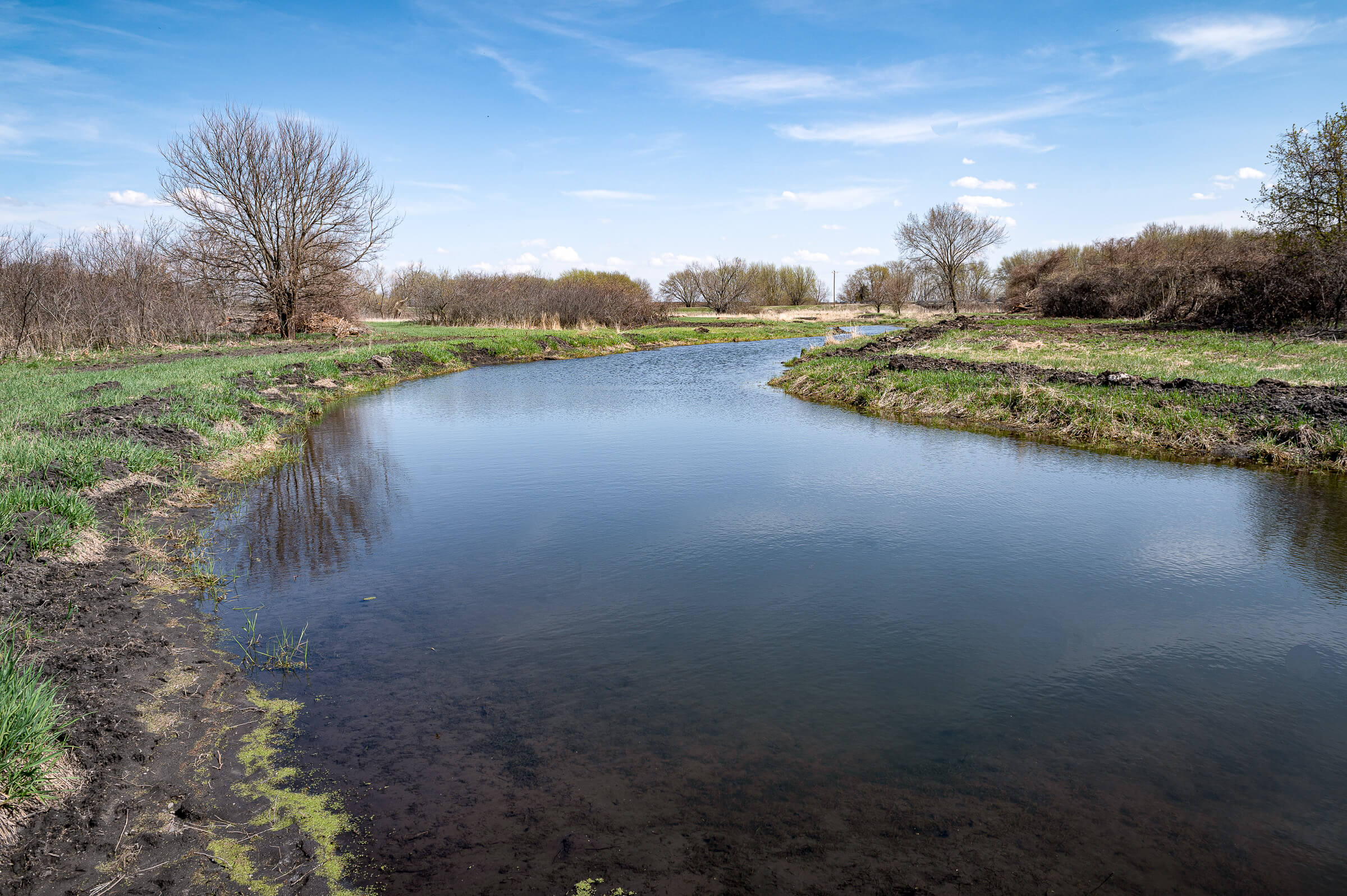 A wide c-shaped stream called an Oxbow sits between gra