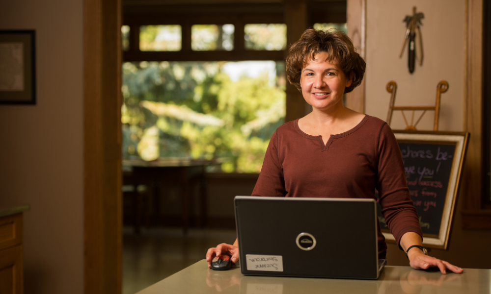 Suzanne Shirbroun sits at her kitchen table using the S